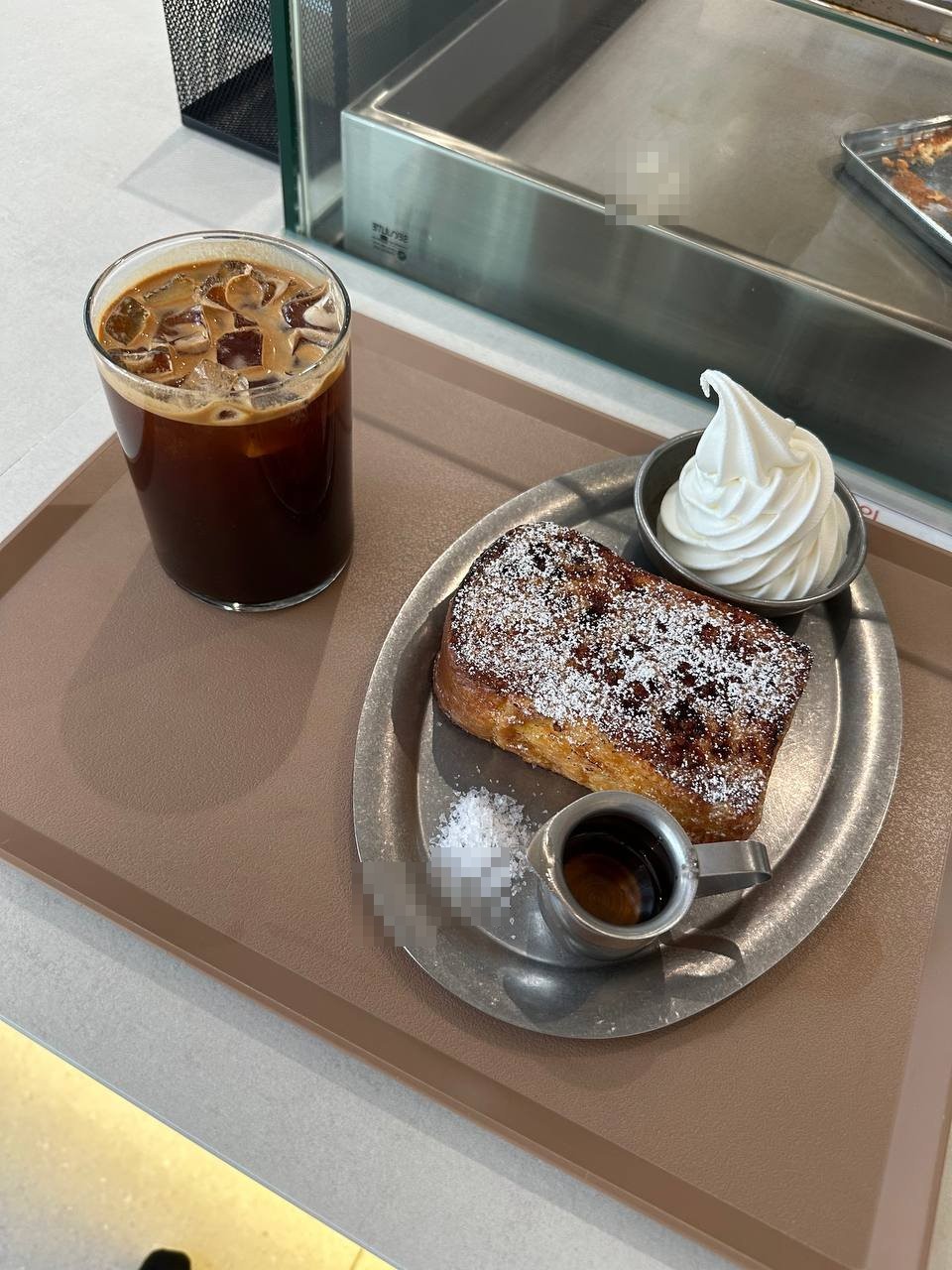 크래킹커피의 프렌치토스트와 아이스 아메리카노, 초콜릿칩 토스트에 설탕가루와 휘핑크림 시럽이 서빙된 모습